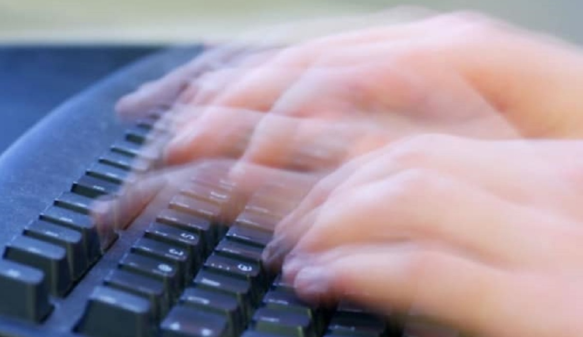hands typing fast on keyboard